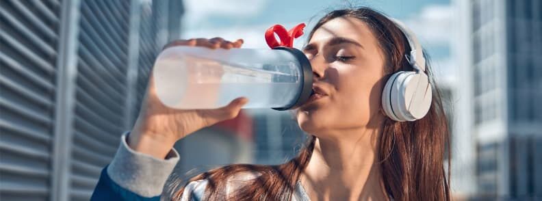 woman drinking water hydrated while traveling 妇女在旅行时喝水